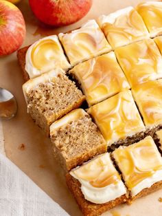 slices of cake sitting on top of a cutting board next to apples