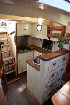 a kitchen with an oven, sink and ladder to the ceiling in front of it