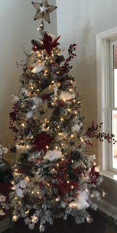 a white christmas tree with red and silver decorations