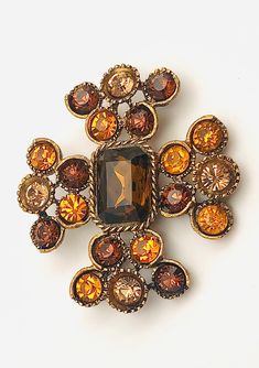 DESCRIPTION: What a pretty pin this is.  The pin is a stylized Maltese Cross. Smokey topaz, amber, & sable faceted, round-cut crystals are set into individual petal baskets. The pretty smokey topaz center crystal is rectangular & surrounded by a rope border. The bronze-tone metal and black enameling (Japanning) give the piece an antique look.  All the crystals are gold foiled & set open back. The reverse is texturized.  Enjoy! *  *  *   *DIMENSIONS: ~2-1/4" x 2" *Wt.: ~32 gms *HALLMARK(s): unsig Rope Border, Smokey Topaz, Pretty Pins, Maltese Cross, Amber Color, Vintage Costume Jewelry, Color Crystal, Black Enamel, Vintage Costumes