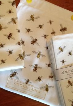 three bees printed napkins sitting next to each other on top of a wooden table