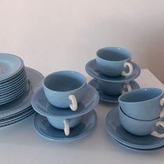 a table topped with blue cups and saucers