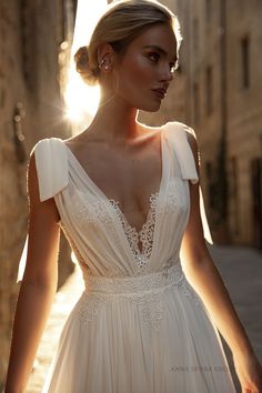 a woman in a white dress is walking down the street with her hand on her hip