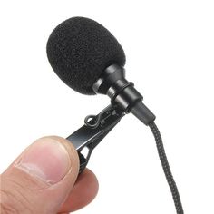 a microphone being held by a hand with a cord attached to the top of it