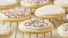 there are many cookies that have sprinkles on them and white frosting