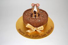 a birthday cake decorated with an image of a monkey on top and gold ribbon around the edges