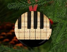 a wooden ornament hanging from a christmas tree with music notes on the keys