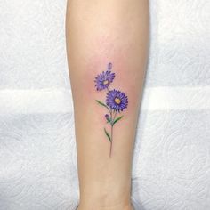 a purple flower tattoo on the ankle