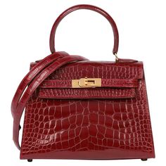 Hermès Rouge H Shiny Alligator Leather Vintage Kelly 20cm Brand- Hermès Model- Kelly 20cm Product Type- Shoulder, Top Handle Serial Number- U* Age- Circa 1991 Accompanied By- Hermès Dust Bag, Box, Shoulder Strap Colour- Rouge H Hardware- Gold Material(s)- Alligator Leather Authenticity Details- Date Stamp Height- 14cm Width- 20cm Depth- 9cm Handle Drop- 8cm Additional Strap Drop- 52cm Interior- Red Leather Closure- Turn Lock Country of Origin- France Condition Rating- Excellent Exterior Conditio Alligator Handbags, Gold Tote Bag, Vintage Kelly, Hermes Kelly Bag, Kelly Bag, Hermes Bags, Shoulder Tote, Designer Bags, Birkin Bag