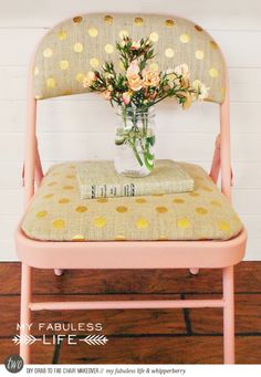 a vase filled with flowers sitting on top of a pink chair