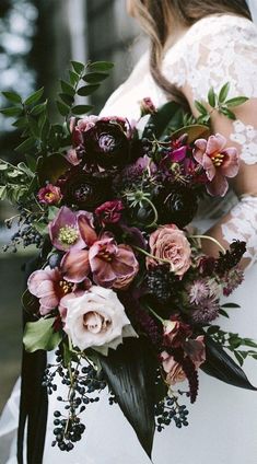 a woman holding a bouquet of flowers in her hands