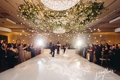 a bride and groom walk down the aisle at their wedding reception in front of an audience