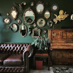 a living room filled with furniture and lots of mirrors on the wall behind a leather couch