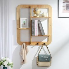 there is a shelf with books on it and a purse hanging from the wall next to it