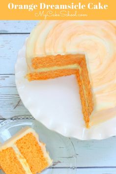 an orange cake with white frosting on a plate next to a piece of cake