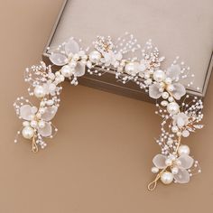 the bridal hair comb is decorated with pearls and flowers, along with other accessories