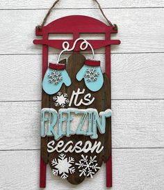 a wooden sign that says it's frozen season with mittens and snowflakes