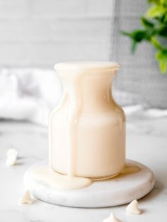 a white vase sitting on top of a marble table