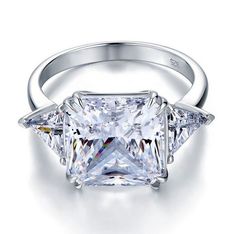 a princess cut diamond ring with three side stones on the band and an inscription that reads diamonds