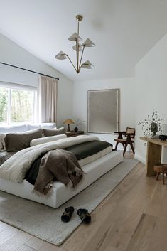 a large bed sitting in the middle of a bedroom next to a wooden table and chairs