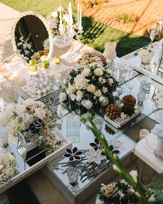 a table topped with lots of different types of flowers and vases filled with white flowers