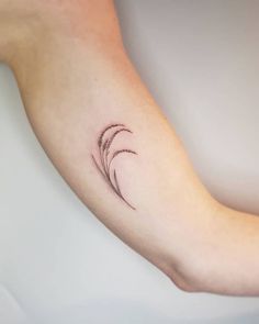 a small feather tattoo on the arm