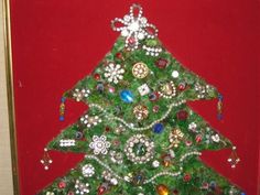 a christmas tree made out of beads on a red background with a gold framed frame