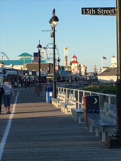 people walking on the boardwalk at an amusement park