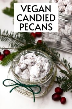 vegan candied pecans in a glass jar with holly and berries around it