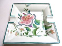 a white and green tray with flowers painted on it