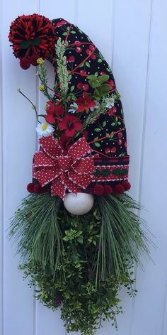 a christmas wreath hanging on the side of a white door with red and green decorations