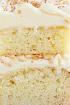 a piece of cake with white frosting and coconut on top is shown in close up