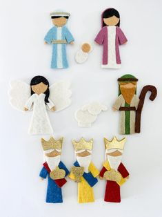 felt angels and angel figurines are arranged on a white surface