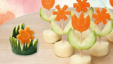 there are some cake pops decorated with flowers and cucumbers on the table next to each other