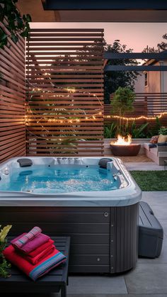 a hot tub sitting on top of a patio next to a fire pit