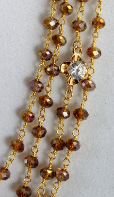 "Absolutely stunning statement necklace! This is a multi-layer necklace made with 4mm Amber Austrian crystals on 24kt gold vermeil. Beautiful Clear Diamond Zirconias set in 18kt gold filled add pop and intrigue to this statement piece. A multi tone gold filled Hamsa pendant measuring 1 1/4\"x1\", hangs from these rich layers. Necklace on model measures 16\"-18\" but is also available in a 18\"-20\" or 20\"-22\" length. There is a gold filled toggle closure that connect all the layers in back. Co Gold Double Strand Crystal Necklace With Faceted Beads, Brown Crystal Necklace With Faceted Beads For Gift, Gold Multi-strand Crystal Necklace As Gift, Gold Multi-strand Crystal Necklace, Multi-strand Crystal Jewelry Gift, Brown Spacer Beads Jewelry Gift, Hamsa Necklace Gold, Hand Pendant, Gold Hamsa