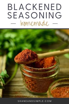 a jar filled with homemade blackened seasoning next to some herbs