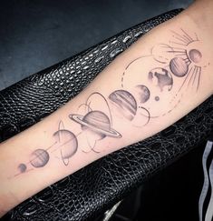 an arm tattoo with planets on it