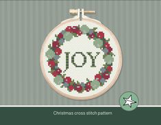 a cross stitch pattern with the word joy in a wreath on it's hoop