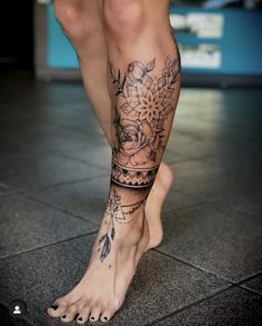 a woman's legs with tattoos and flowers on them