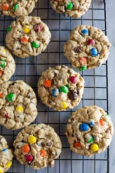 cookies with m & m's and chocolate chips are on a cooling rack, ready to be eaten