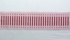 a piece of pink paper with red lines on it and a white wall in the background