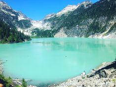 a blue lake surrounded by mountains and trees