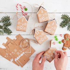 someone is making gingerbread houses out of cardboard and candy canes on the table