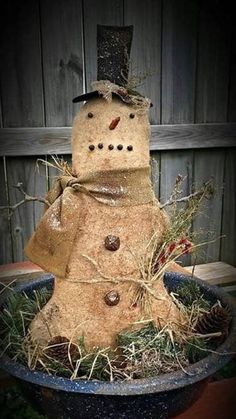 a snowman made out of hay in a planter