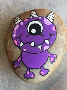 a rock with a purple monster painted on it