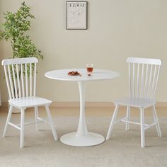 two white chairs and a table in a room