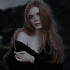 a woman with long red hair is posing for the camera