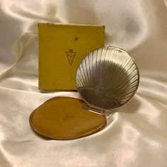 a yellow box sitting on top of a white bed next to a mirror and fan