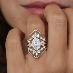 a close up of a person's hand with a diamond ring on their finger